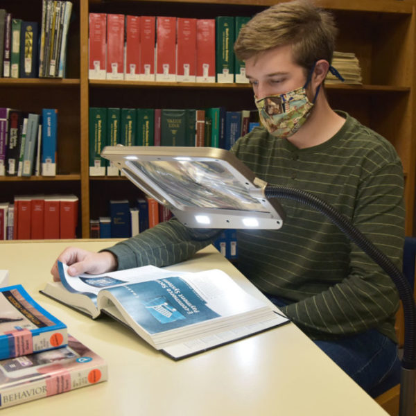 Ben Muckenthaler, a BFA Musical Theatre major, tests out the assistive reading device in the Young Library.