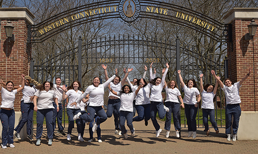 WCSU Nursing students jumping in front of the WCSU gate