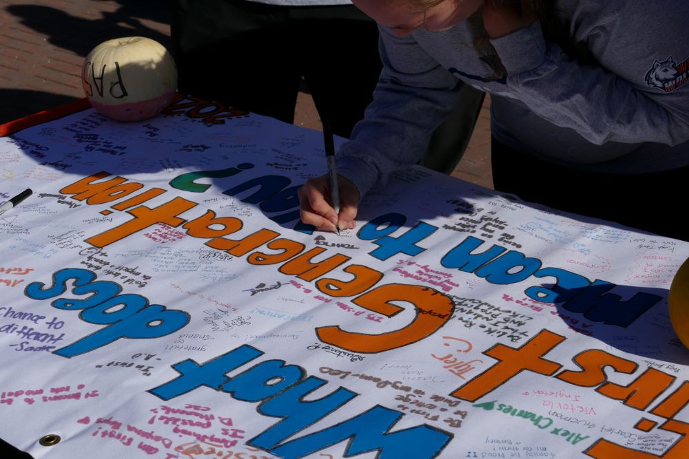 First generation students sign a banner